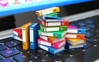 A photo of binders on a keyboard, used for Why Should Federal Agencies Notify NARA About "Unauthorized Disposition" in Government Records?