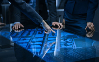 An image of men around a desk pointing at blueprints