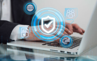 Image of a person using a laptop with shield and checkmark logos in the center of the screen